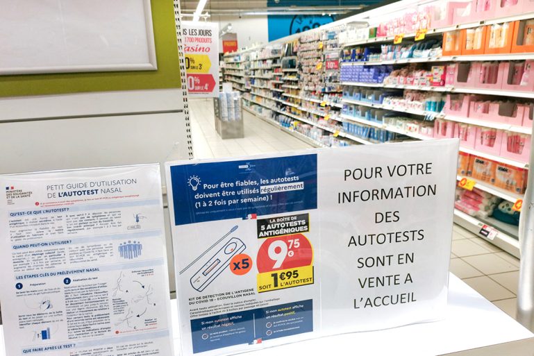 Une affichette dans un supermarché annonçant la vente des autotests à la caisse 