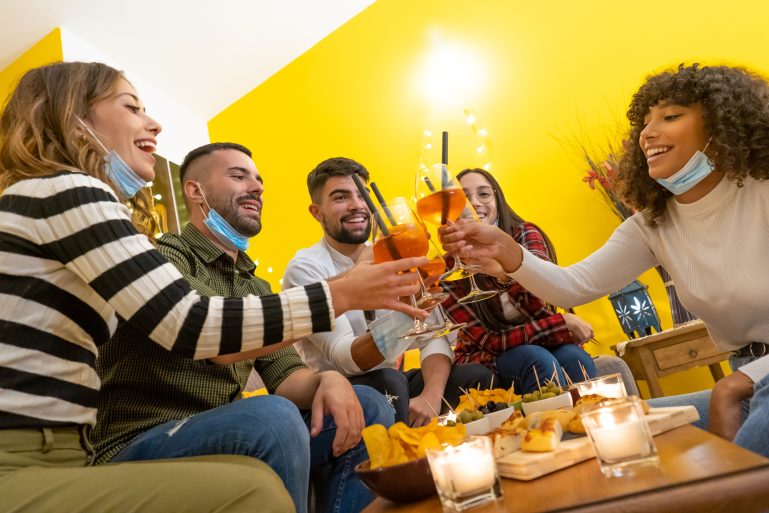 un groupe de jeunes gens trinquent un verre à la main