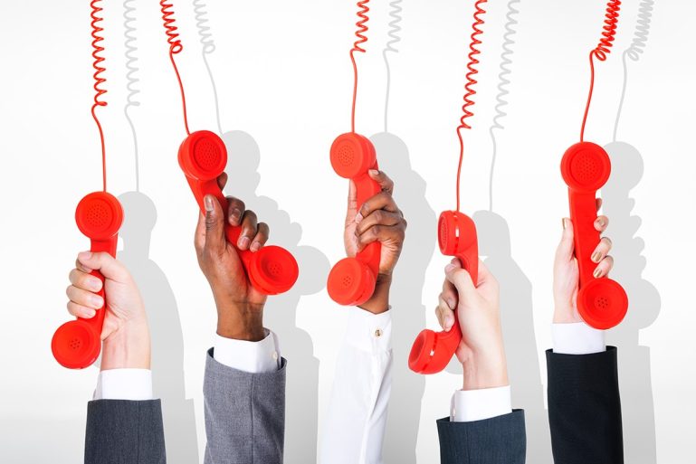 5 mains tiennent le combiné de 5 téléphones rouges