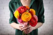Jeune femme tenant un bouquet de renoncules dans ses mains