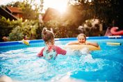 Deux fillettes jouent dans une piscine installée dans le jardin