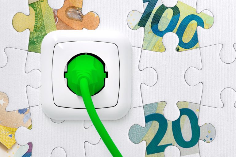 Une prise électrique verte sur un mur en puzzle avec des dessins de billets en euros