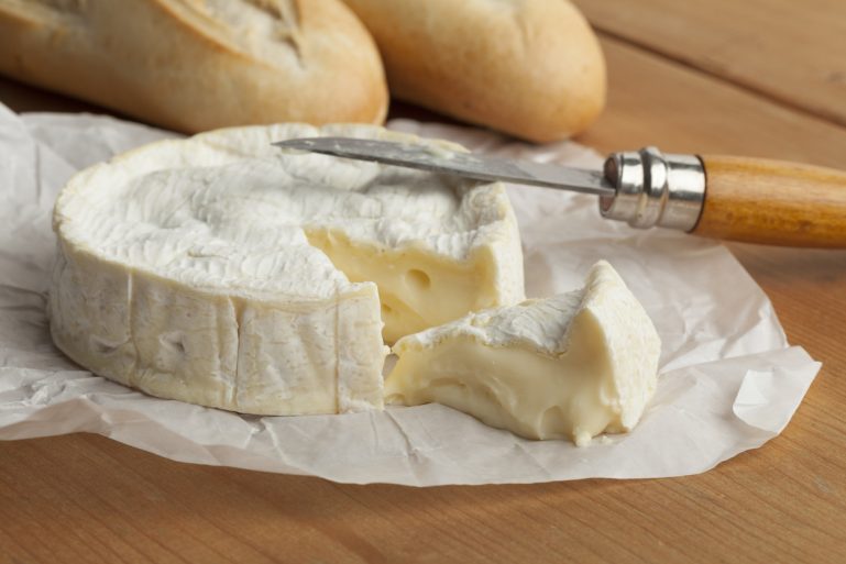 Camembert coulant en train d'être découpé