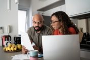 Un couple regarde des documents devant un ordinateur