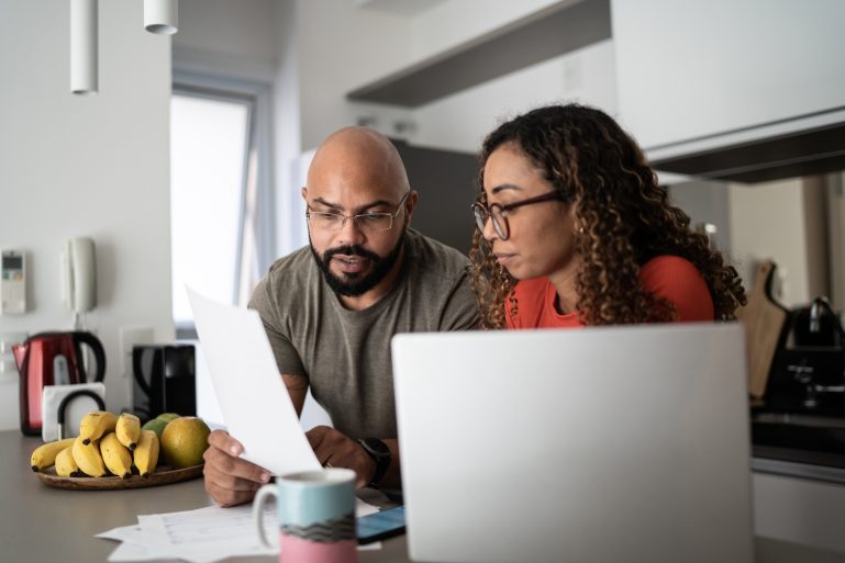 Un couple regarde des documents devant un ordinateur