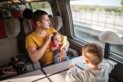 Un père avec ses deux enfants assis dans un TGV