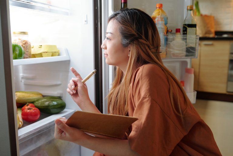 Jeune femme devant son frigo