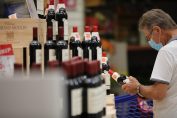 consommateur regardant une bouteille de vin en magasin