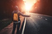 Un homme fait de l'auto stop au bord d'une route