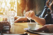 Une femme met un édulcorant dans son café