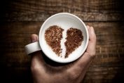 Une tasse de capuccino avec un cœur brisé en chocolat en poudre