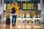Une passagère devant les panneaux d'affichage d'un aéroport.