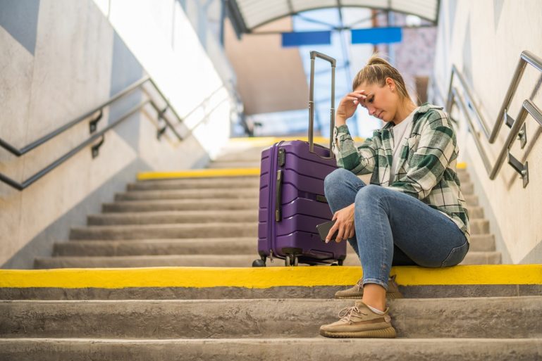 Une femme atterrée assise dans les escaliers d'une gare