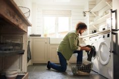 Un homme vidant un lave-linge