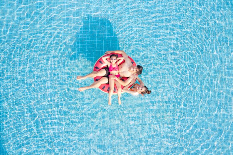Une famille dans une piscine sur une bouée.