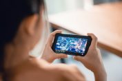Une jeune fille regarde un film sur son smartphone.