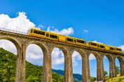 le train jaune sillonne les hauteurs des Pyrénées-Orientales passant sur un aqueduc