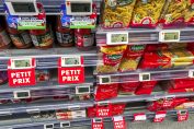 Des étiquettes indiquant de petits prix dans les rayons d’un magasin alimentaire.