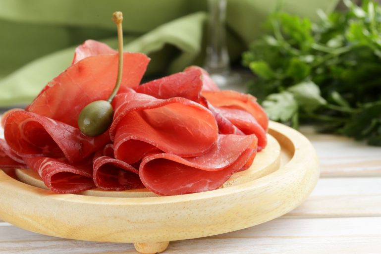 Des tranches de bressaola avec un câpre
