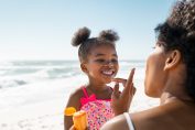 Mère appliquant de la crème solaire à sa fille