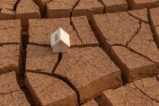 petite maison sur un sol craquelé par la sécheresse