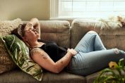 Jeune femme allongée se tenant le ventre