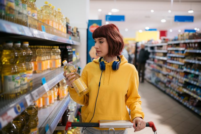 jeune femme achetant de l’huile dans un supermarché