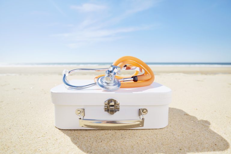 valise et stéthoscope sur une plage au soleil