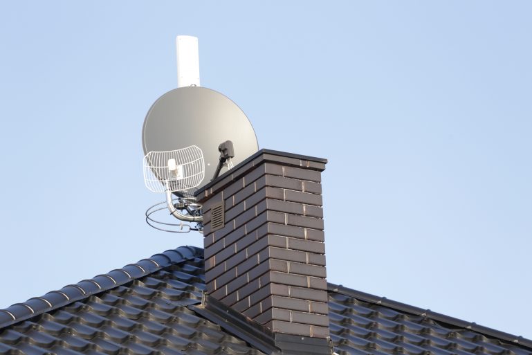 Des antennes, dont une satellite, sur le toit d'une maison