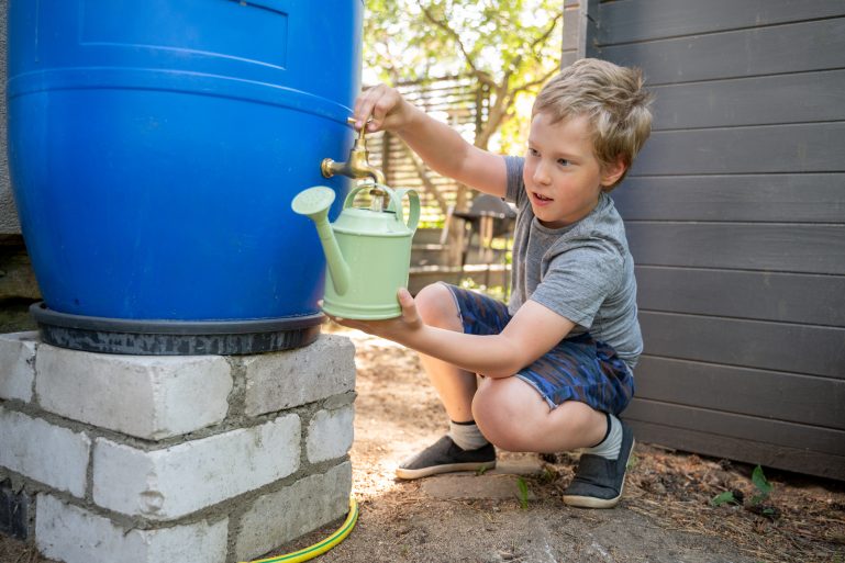 Un enfant puise de l’eau dans un récupérateur