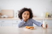 Une petite fille dubitative devant ses biscuits