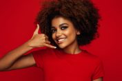 Une jeune femme mime un appel téléphonique avec sa main