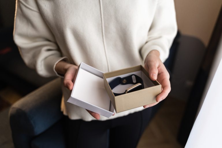Une femme ouvre la boîte d'une montre connectée