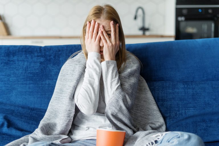 Une femme terrifiée dans son canapé