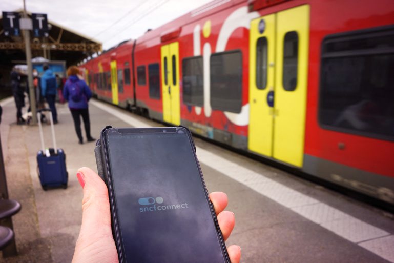 quai de gare et smartphone avec l’appli SNCF Connect