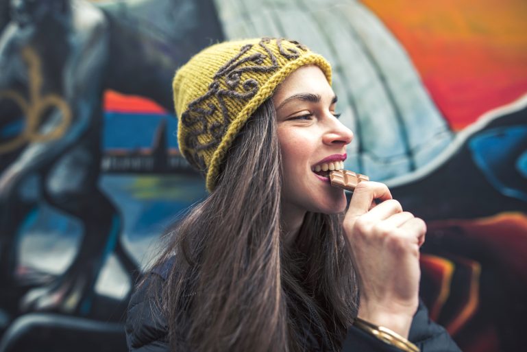 femme croquant dans une tablette de chocolat