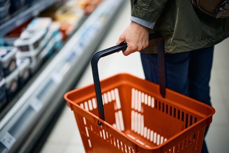 Un homme fait ses courses avec un panier de supermarché