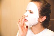 Une jeune femme utilise un masque de beauté jetable.