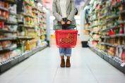 une consommatrice avec un panier vide dans un rayon de supeermarché.