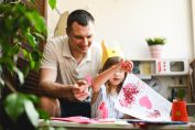 Une petite fille décore une carte avec des paillettes