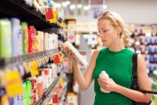 Une femme choisit un gel douche dans un supermarché