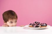 Un enfant regarde avec envie des gâteaux