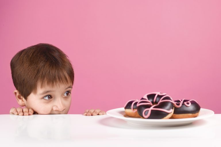 Un enfant regarde avec envie des gâteaux