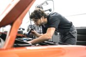 Un garagiste inspecte sous le capot d'une voiture