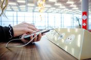 Un smartphone en train d'être rechargé sur des prises USB publiques