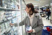Une femme en train de choisir ses yaourts protéinés