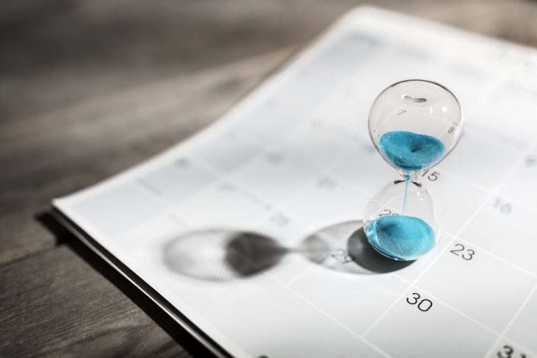 Un sablier sur un calendrier figurant le temps qui passe