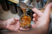Quelqu'un remplit un pot de miel
