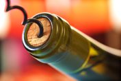 Une bouteille de vin rouge en train d'être débouchée