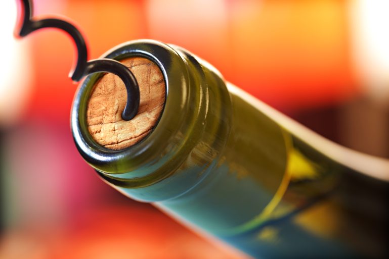 Une bouteille de vin rouge en train d'être débouchée